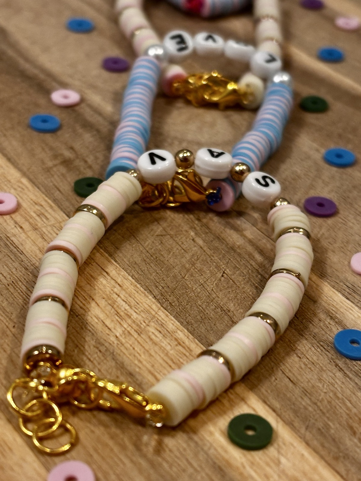 Layered pastel bracelets with gold details